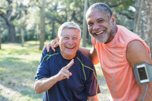 An older man participating in Parkinson’s Wellness Recovery exercises outdoors with his friend.