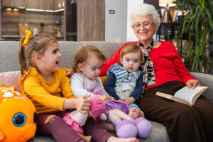 An older woman reads to her grandchildren, utilizing ideas for purposeful living for seniors.