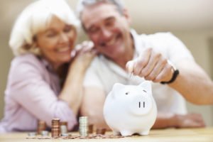 happy senior couple saving money at home