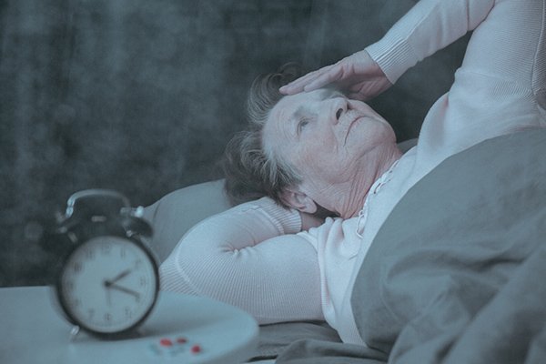 Senior woman having sleep disorder, lying in bed